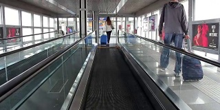 在火车站或机场提着箱子走路的女人