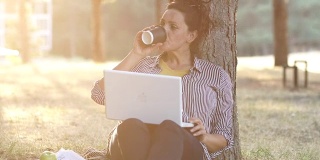 Adult woman using laptop in nature