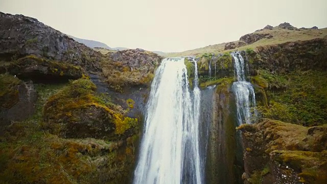 冰岛山脉之间的Gljufrabui瀑布的航拍。水流湍急的风景