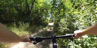 夏天，骑自行车的女孩骑在树林里的一条土路上