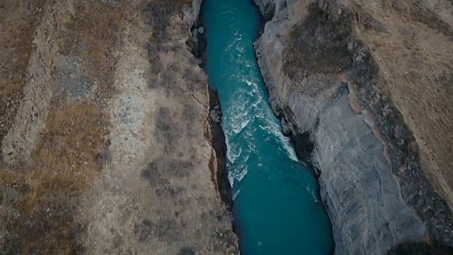 峡谷峡谷瀑布鸟瞰图。直升机飞过冰岛的山谷和湍急的河流