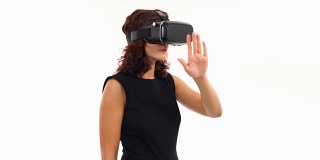 年轻的女商人正在使用虚拟现实眼镜工作，在白色的屏幕上做孤立的手势