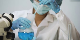 实习生采集蓝色液体样本并在实验室显微镜下检查