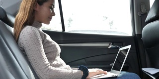 女人在车上用笔记本电脑