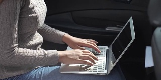近距离的女人在车上使用笔记本电脑