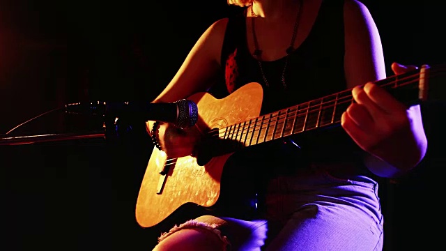 女人一边弹4k电吉他一边唱歌