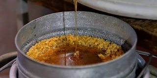 从蜂蜜提取器中取出的蜂蜜通过饲料过滤到混凝土中