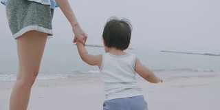 母亲和男婴在华欣海滩散步