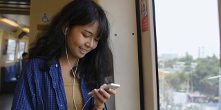 年轻的亚洲女性在听音乐。