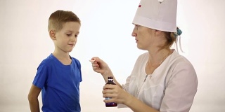 医生给一个小男孩吃药