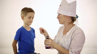 医生给一个小男孩吃药视频素材模板下载
