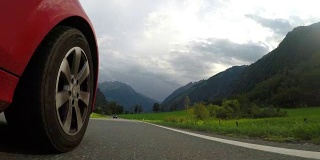 Close up front car wheel on the asphalt alpine road