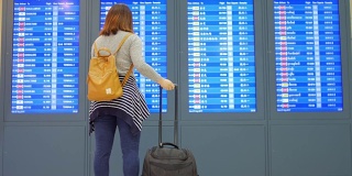 一名女乘客在离港机场办理登机手续前，用手机在数字登机牌上检查她的航班