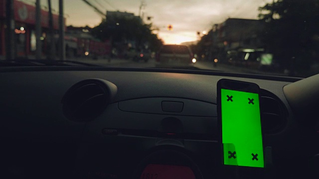 亚洲女性在车里使用智能手机的特写，绿屏