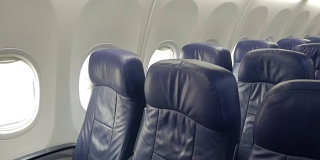 商用飞机机舱内部，乘客座位为蓝色。