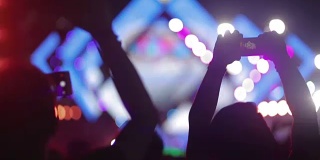 人群在音乐会上举起双手剪影，为音乐节欢呼的人群