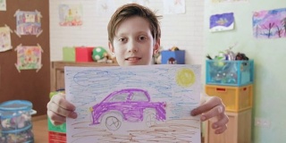 可爱的微笑的男孩展示照片的汽车看着相机