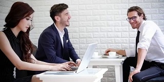 一群商务人士在开会时使用电脑。