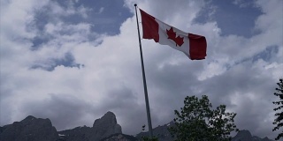 加拿大国旗对山区景观-慢动作