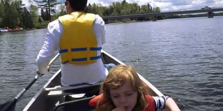 一名男子带着女儿在安大略湖乡村划船