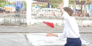 一位老妇人在停车场练习中国手扇子舞