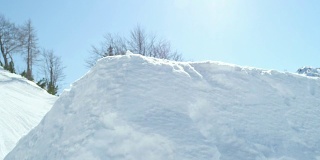 慢动作:滑雪板跳过踢球，在阳光灿烂的雪园飞过太阳