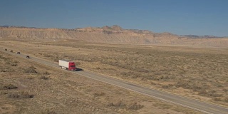 空中半卡车与集装箱拖车通过广阔的沙漠在犹他州