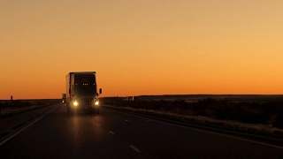 近景:黄昏时分，半挂卡车在乡村公路上行驶视频素材模板下载