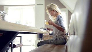 金发女人放松，阅读和早茶视频素材模板下载