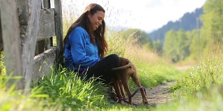 年轻的加拿大土著妇女和她的狗玩