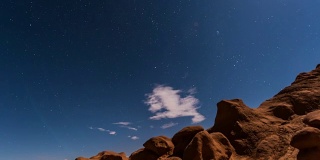 时间推移的镜头与满月上升的夜空，或月亮上升，在犹他州的哥布林山谷州立公园显示的云，星星，和峡谷在荒野自然的轮廓