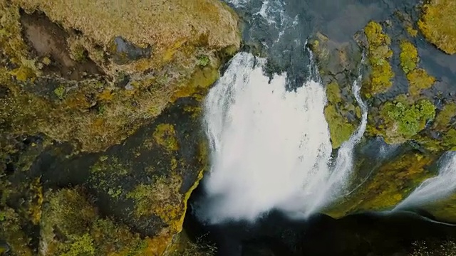 冰岛美丽的Gljufrabui瀑布鸟瞰图。一架直升机飞过一股水流，从悬崖上落下