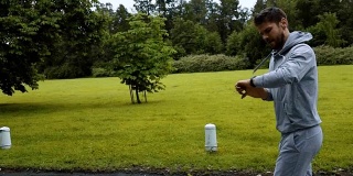 男人在绿林公园跑步训练和看时钟的手臂