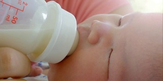母亲用奶瓶喂婴儿。幸福的家庭观念，渴望在没有喧闹的家中无忧无虑。2次