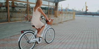 户外时尚肖像优雅的金发女士骑她的嬉皮复古自行车在复古时尚的衣服。享受夏日，在港口摆好姿势。休闲的生活方式。慢动作