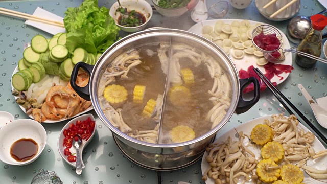 火锅概念的亚洲美食。在桌上沸腾的肉汤。用小匙在肉汤里煮肉