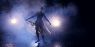 一位女舞者匆匆穿过黑暗的舞台。