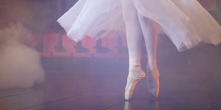 在雾气弥漫的房间里跳舞的芭蕾舞者的脚。