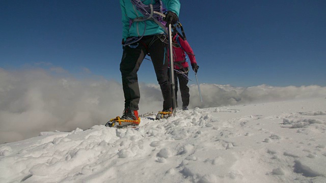 两名女性登山队员徒步沿着冰川与暴风雨的天气接近。