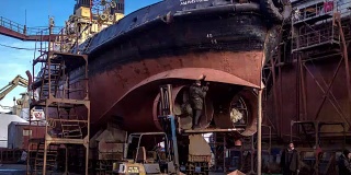 工人们在船厂的浮船坞修理旧船。船舶螺旋桨重建。渔船焊接延时全高清视频