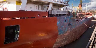 工人们在船厂的浮船坞修理和油漆船只。船上油漆工在工作。船染色延时全高清视频