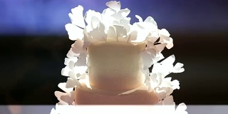白色婚礼蛋糕与鲜花的特写。