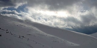 壮观的天空和白雪皑皑的群山中的阳光