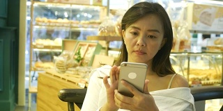 成熟的女人在咖啡店用手机