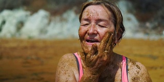 老妇人在脸上涂泥。
