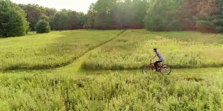 15岁少女骑自行车在草地上的小径在ed. Poconos，宾夕法尼亚州