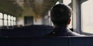 年轻人坐在超高清中，独自透过移动的火车窗口看风景