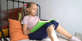 女孩在家里慢慢地、清晰地读着一本书