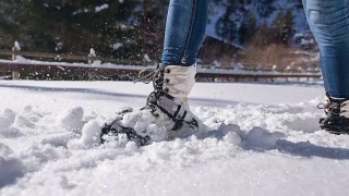 在新雪上穿雪鞋的女人视频素材模板下载