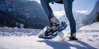年轻女子在山腰穿雪鞋